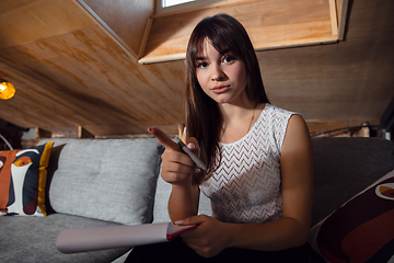 Image showing Young woman talking, working during videoconference with colleagues at home office