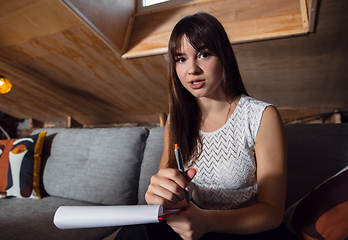 Image showing Young woman talking, working during videoconference with colleagues at home office