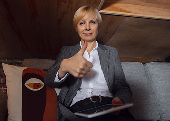 Image showing Young woman talking, working during videoconference with colleagues at home office