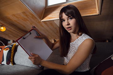 Image showing Young woman talking, working during videoconference with colleagues at home office