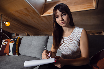 Image showing Young woman talking, working during videoconference with colleagues at home office