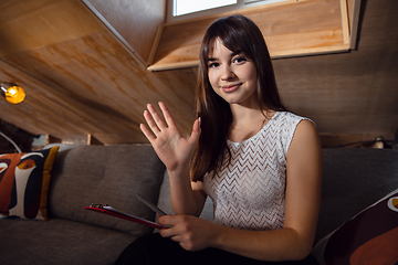 Image showing Young woman talking, working during videoconference with colleagues at home office