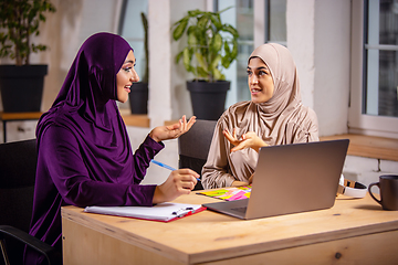 Image showing Happy two muslim women at home during lesson, studying near computer, online education