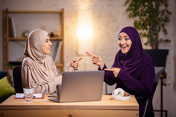 Image showing Happy two muslim women at home during lesson, studying near computer, online education