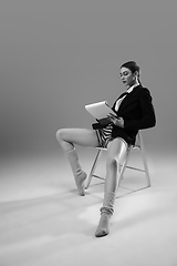 Image showing Young fashionable, stylish woman wearing jacket and socks working from home. Fashion during insulation \'cause of coronavirus pandemic