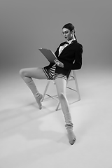 Image showing Young fashionable, stylish woman wearing jacket and socks working from home. Fashion during insulation \'cause of coronavirus pandemic