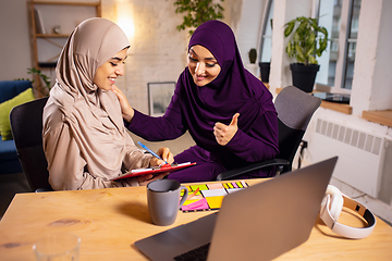 Image showing Happy two muslim women at home during lesson, studying near computer, online education