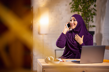 Image showing Happy muslim woman at home during online lesson. Modern technologies, remote education, ethnicity concept