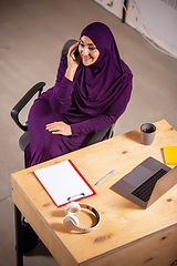 Image showing Happy muslim woman at home during online lesson. Modern technologies, remote education, ethnicity concept