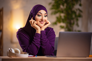 Image showing Happy muslim woman at home during online lesson. Modern technologies, remote education, ethnicity concept