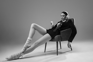 Image showing Young fashionable, stylish woman wearing jacket and socks working from home. Fashion during insulation \'cause of coronavirus pandemic