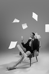 Image showing Young fashionable, stylish woman wearing jacket and socks working from home. Fashion during insulation \'cause of coronavirus pandemic