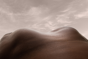 Image showing Detailed texture of human skin. Close up shot of young african-american male body like landscape with the sky background