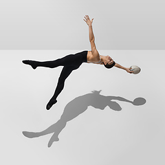 Image showing Beautiful young male athlete practicing on white studio background with shadows in jump, air flying