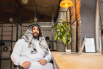 Image showing Arabian businessman working in office, business centre using devicesm gadgets. Lifestyle