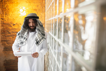 Image showing Arabian businessman working in office, business centre using devicesm gadgets. Lifestyle