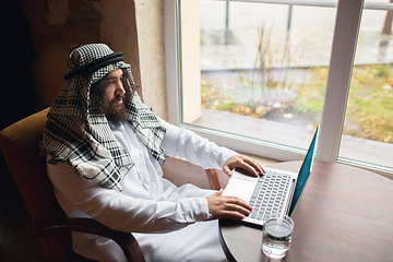 Image showing Arabian businessman working in office, business centre using devicesm gadgets. Lifestyle