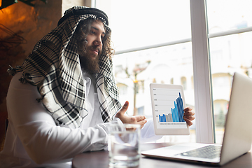 Image showing Arabian businessman working in office, business centre using devicesm gadgets. Lifestyle