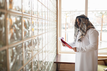 Image showing Arabian businessman working in office, business centre using devicesm gadgets. Lifestyle