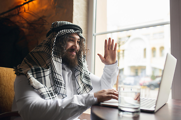 Image showing Arabian businessman working in office, business centre using devicesm gadgets. Lifestyle