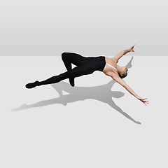 Image showing Beautiful young male athlete practicing on white studio background with shadows in jump, air flying