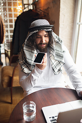 Image showing Arabian businessman working in office, business centre using devicesm gadgets. Lifestyle