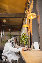 Image showing Arabian businessman working in office, business centre using devicesm gadgets. Lifestyle