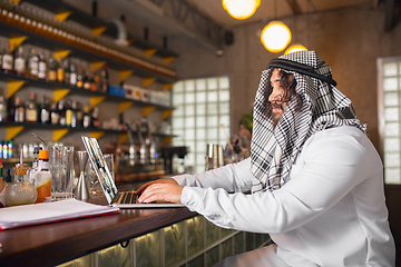 Image showing Arabian businessman working in office, business centre using devicesm gadgets. Lifestyle