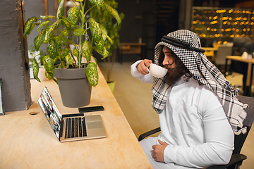 Image showing Arabian businessman working in office, business centre using devicesm gadgets. Lifestyle