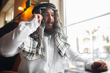 Image showing Arabian businessman working in office, business centre using devicesm gadgets. Lifestyle