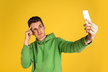 Image showing Portrait of young caucasian man isolated on yellow studio background