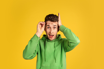 Image showing Portrait of young caucasian man isolated on yellow studio background