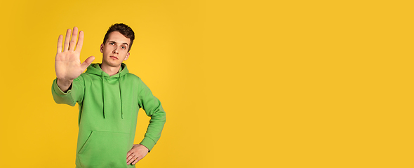 Image showing Portrait of young caucasian man isolated on yellow studio background