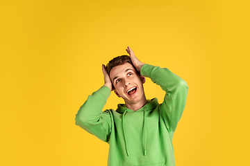 Image showing Portrait of young caucasian man isolated on yellow studio background