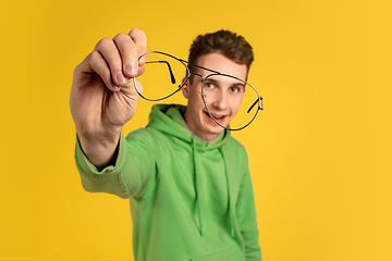 Image showing Portrait of young caucasian man isolated on yellow studio background