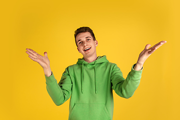 Image showing Portrait of young caucasian man isolated on yellow studio background