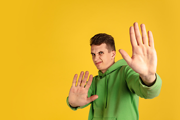 Image showing Portrait of young caucasian man isolated on yellow studio background