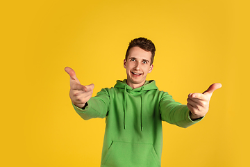 Image showing Portrait of young caucasian man isolated on yellow studio background