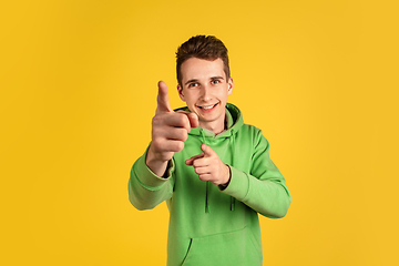 Image showing Portrait of young caucasian man isolated on yellow studio background