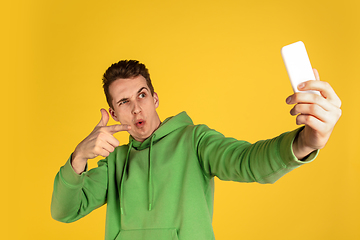 Image showing Portrait of young caucasian man isolated on yellow studio background