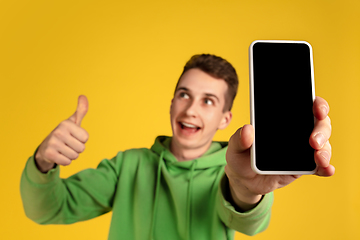 Image showing Portrait of young caucasian man isolated on yellow studio background