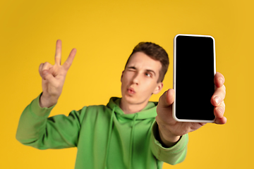 Image showing Portrait of young caucasian man isolated on yellow studio background