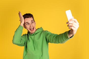 Image showing Portrait of young caucasian man isolated on yellow studio background