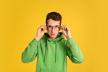 Image showing Portrait of young caucasian man isolated on yellow studio background