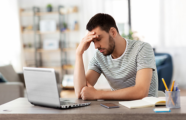 Image showing stressed man with laptop working at home office