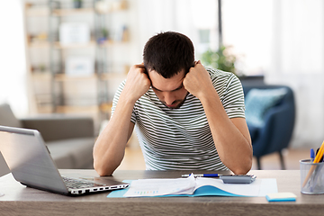 Image showing man with files and calculator works at home office