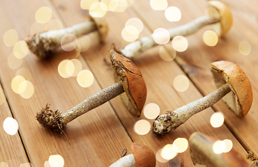 Image showing brown cap boletus mushrooms on wooden background