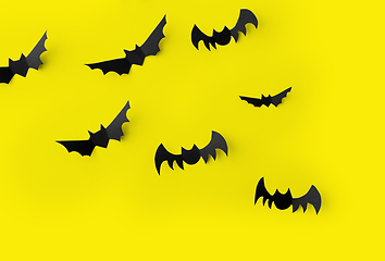 Image showing flock of black paper bats over yellow background