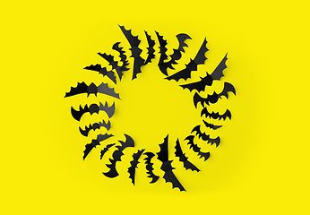 Image showing flock of black paper bats over yellow background