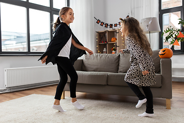 Image showing girls in halloween costumes dancing at home